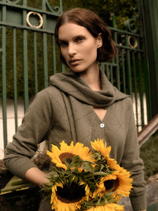 Woman holding sunflowers in front of a green gate